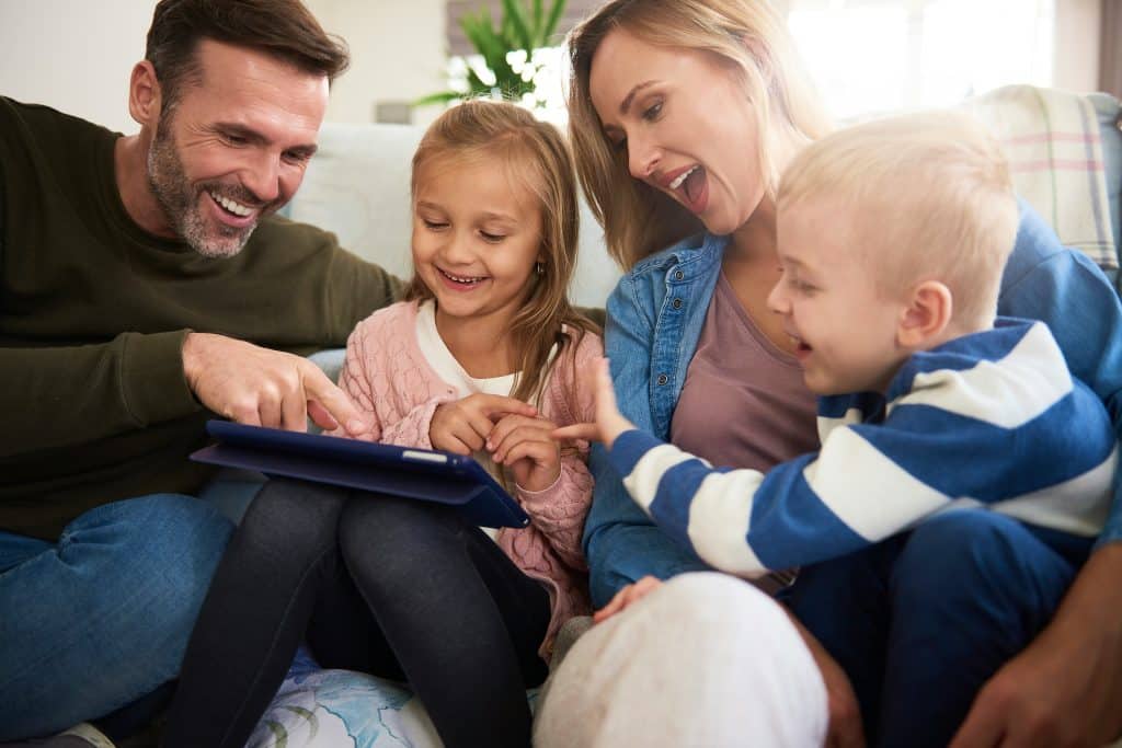 Familie mit tablet verbringt die Zeit im Wohnzimmer. Berater Plattform für HYLA Beratung und Ansprechpartner