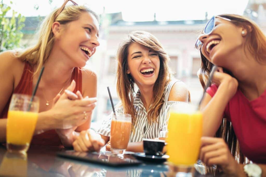Drei Junge Frauen haben Spass und trinken nebenbei ein FitLine Getränk