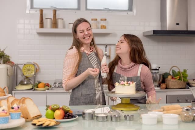 Eine Mutter dekoriert mit ihrer Tochter eine Torte. Kuchen und Desserts mit dem Thermomix.
