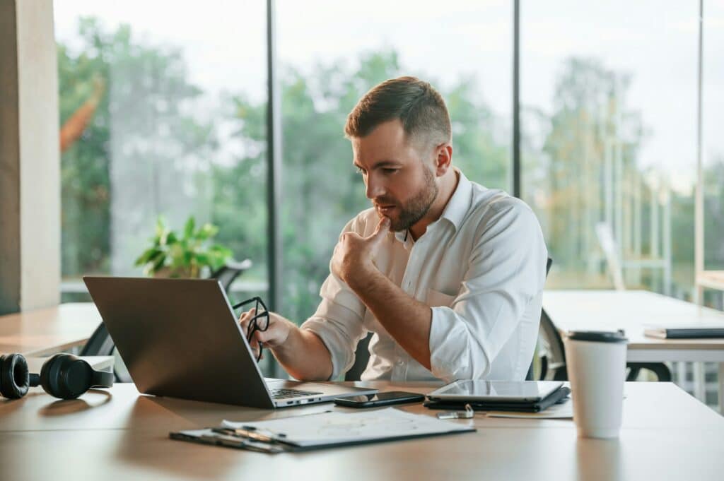 Berater arbeitet im Büro und sucht nach Möglichkeiten, online besser gefunden zu werden.