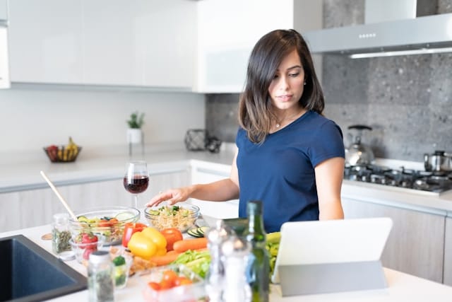 Person bereitet frische Zutaten in einer modernen Küche zu – passend zum Vergleich verschiedener Thermomix Modelle.