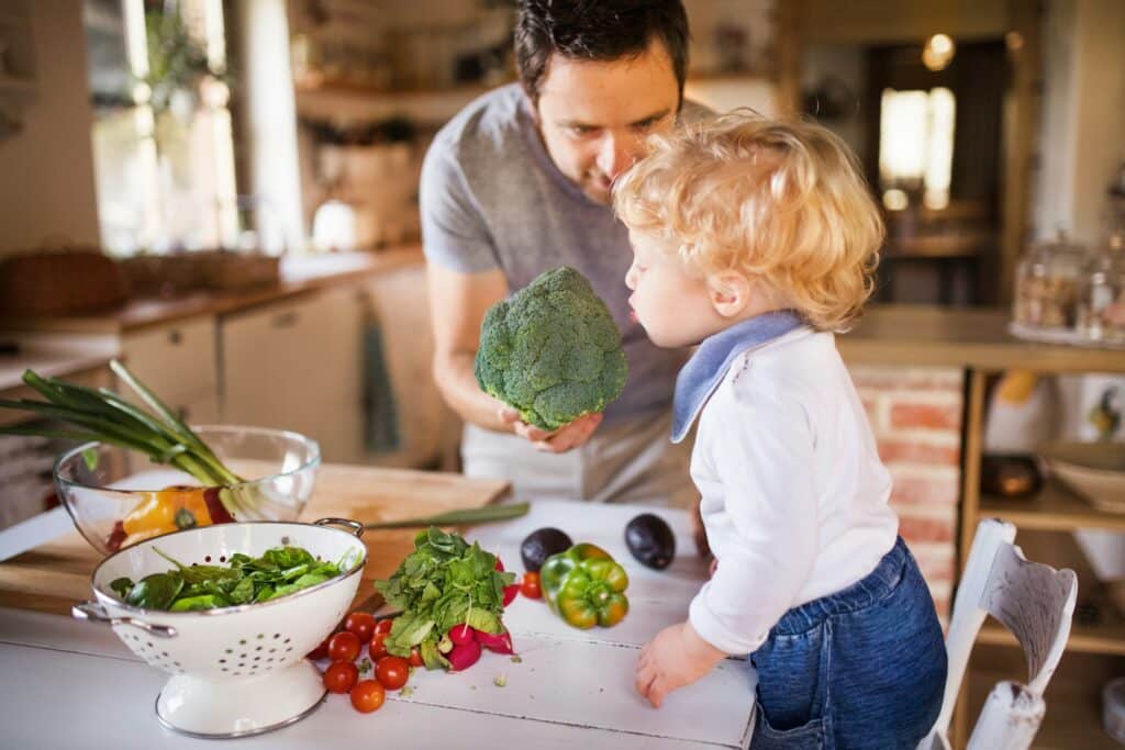 Vater kocht gemeinsam mit seinem Kind in einer modernen Küche – Thermomix Modelle erleichtern das Kochen im Familienalltag.